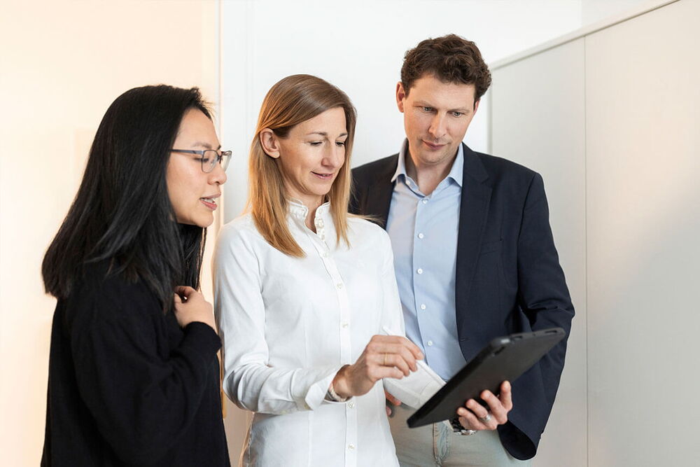 Besprechung von drei Ärzten am Tablet